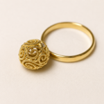 Sfera in filigrana d'oro lavorata a mano sospesa al gambo dell'anello